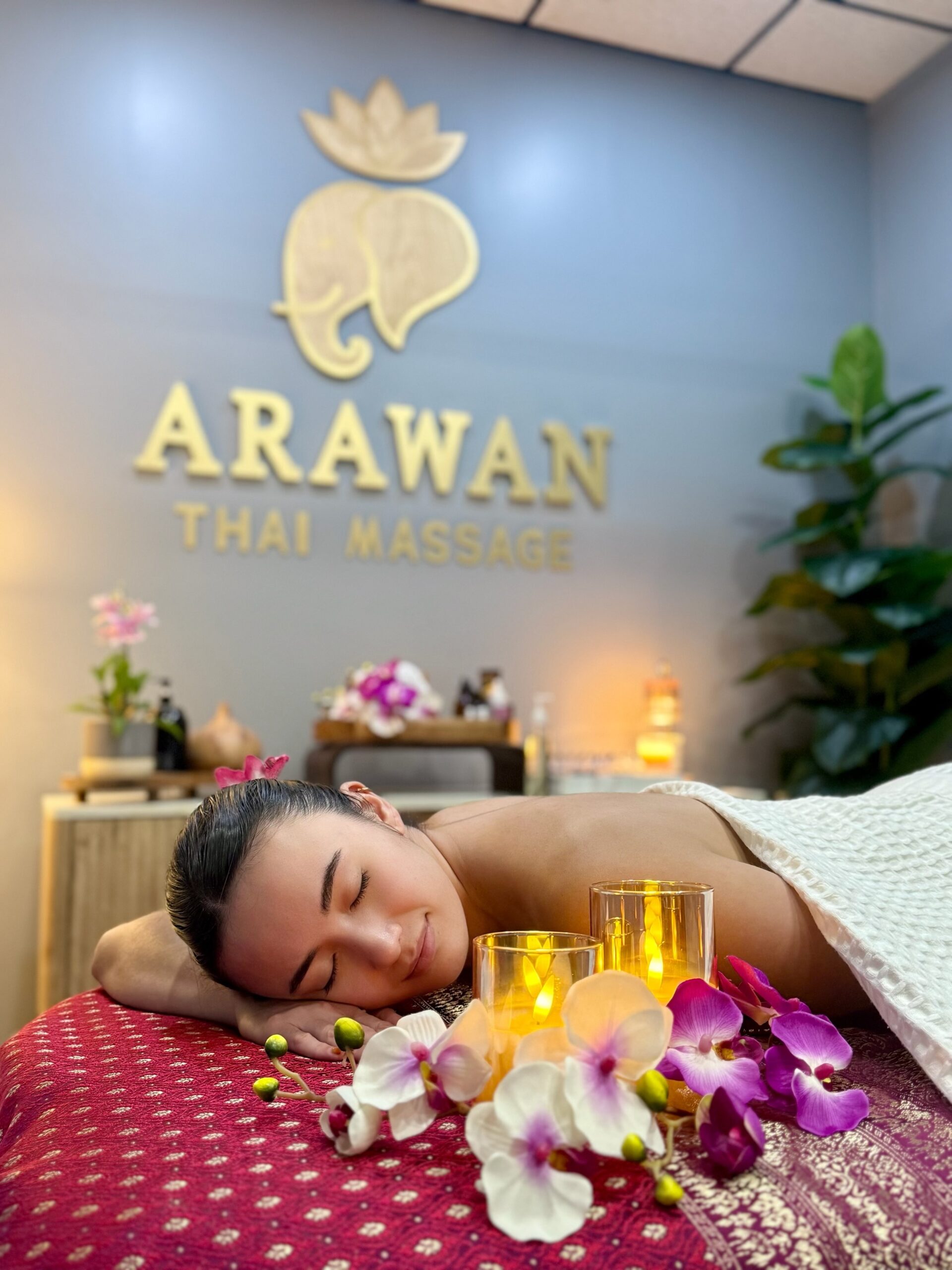 A woman lay on a red massage bed in the room.