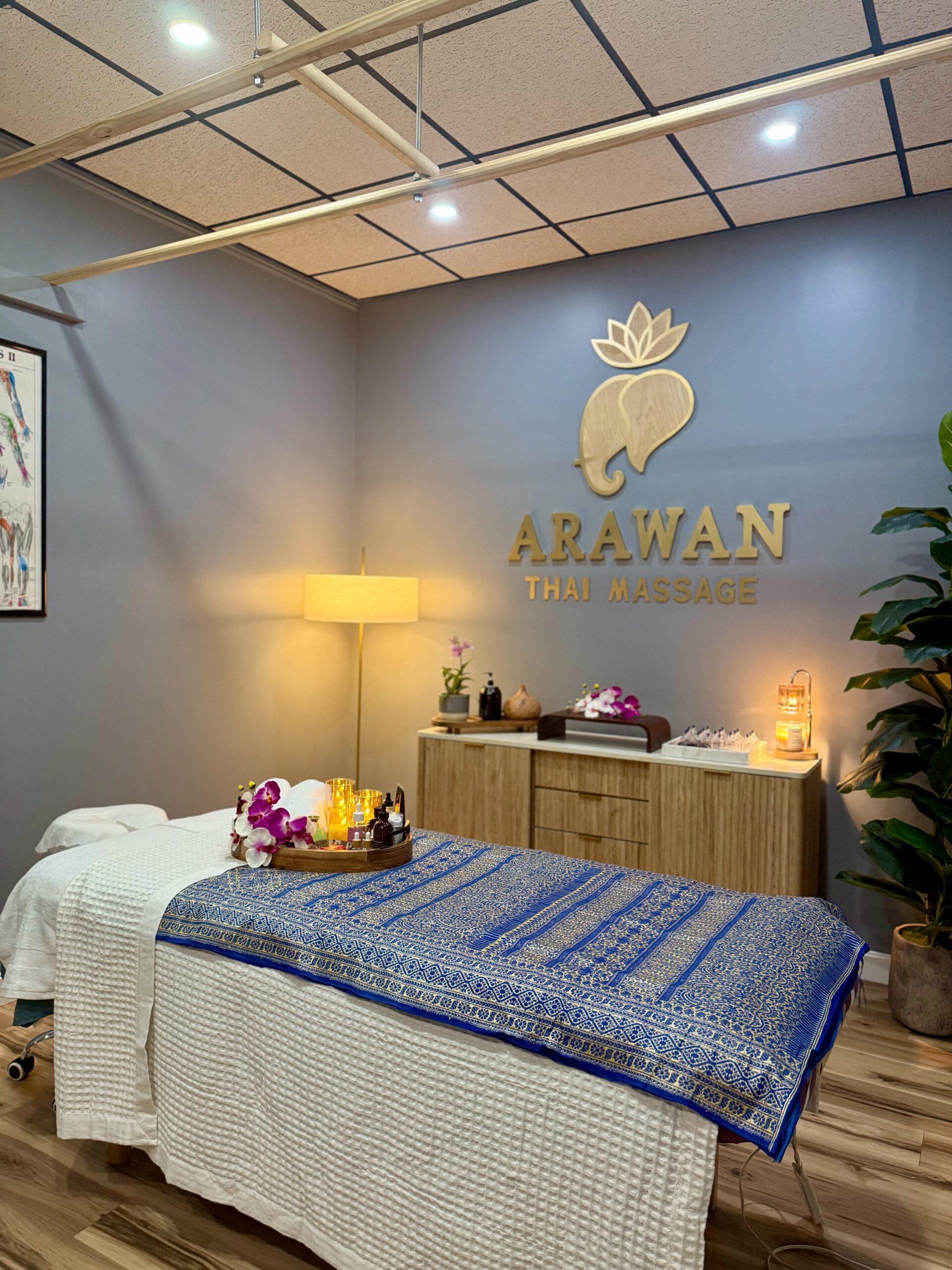 A massage studio with wood hanging on the ceiling.