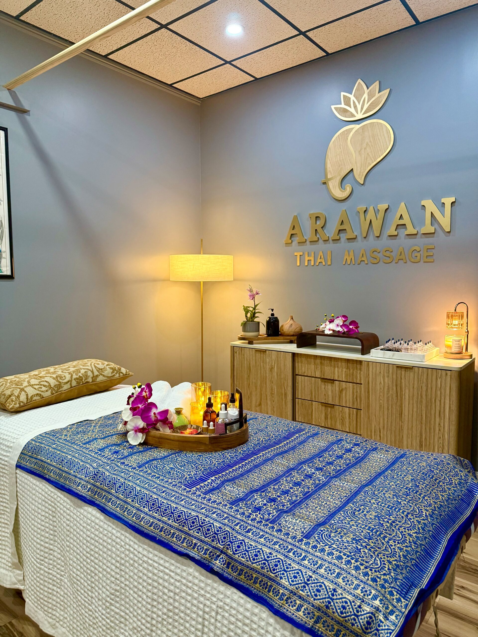 A blue massage studio with golden logo on the wall.