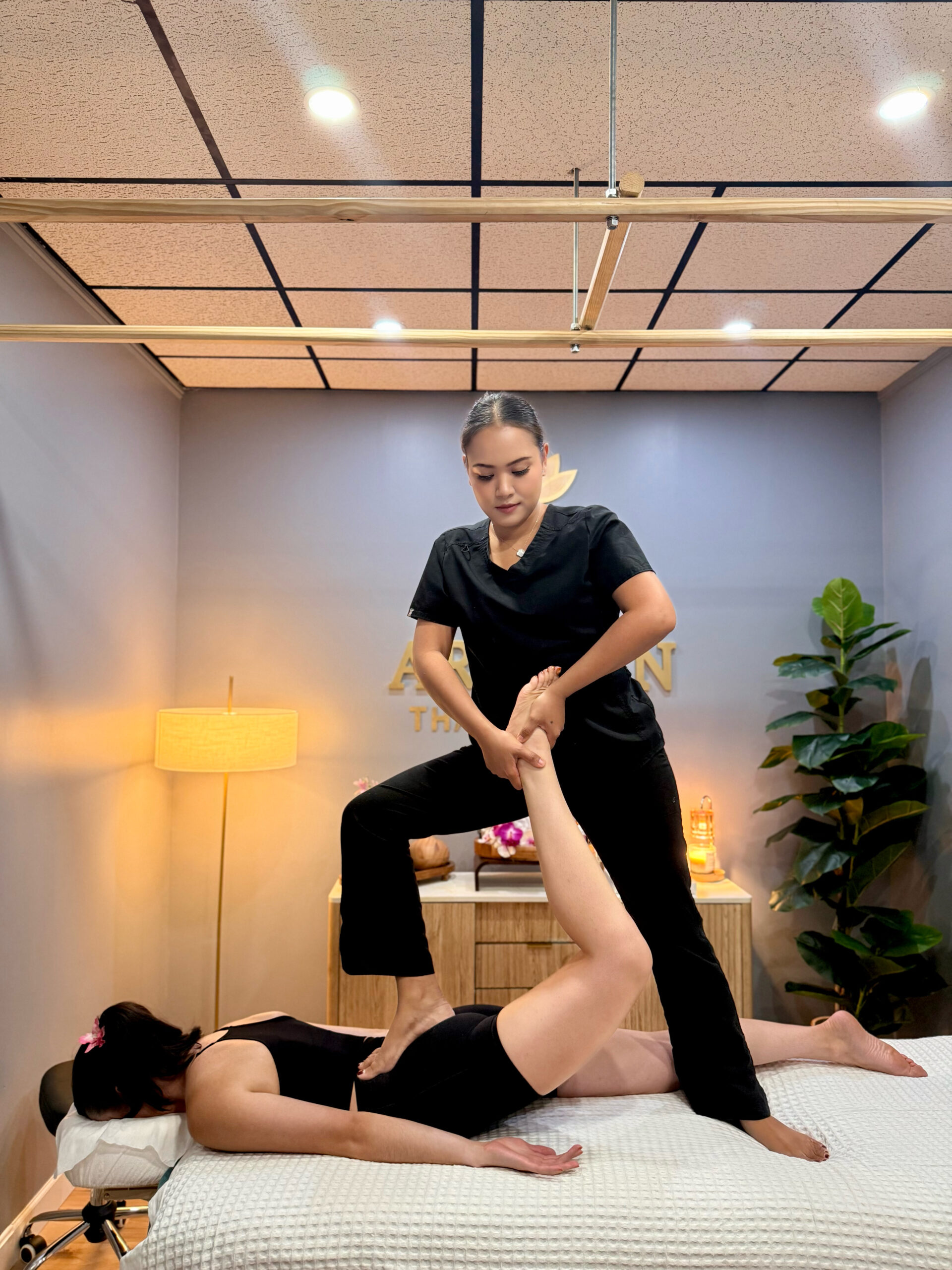 A massage therapist stretching a woman leg.